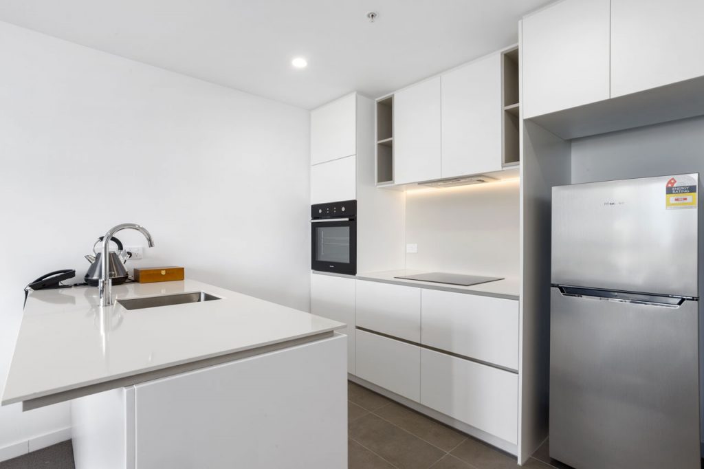 Kitchen and fridge at 1 bedroom king - The Sebel Moonee Ponds