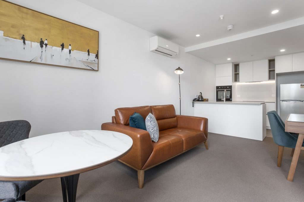 Lounge and kitchen in 1 bedroom apartment king at The Sebel Moonee Ponds