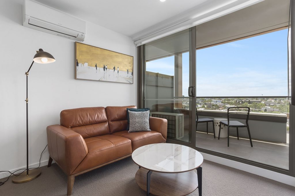 Sofa and artwork plus view of balcony and beyond at The Sebel Moonee Ponds